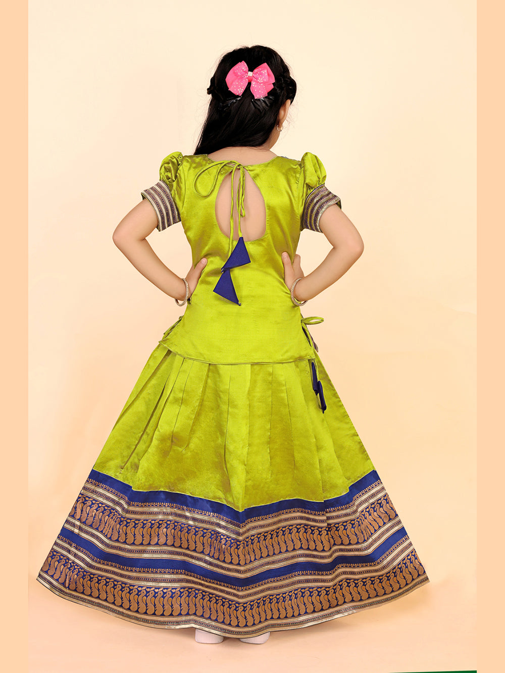 Green dress with a patterned skirt worn by a person on a beige background