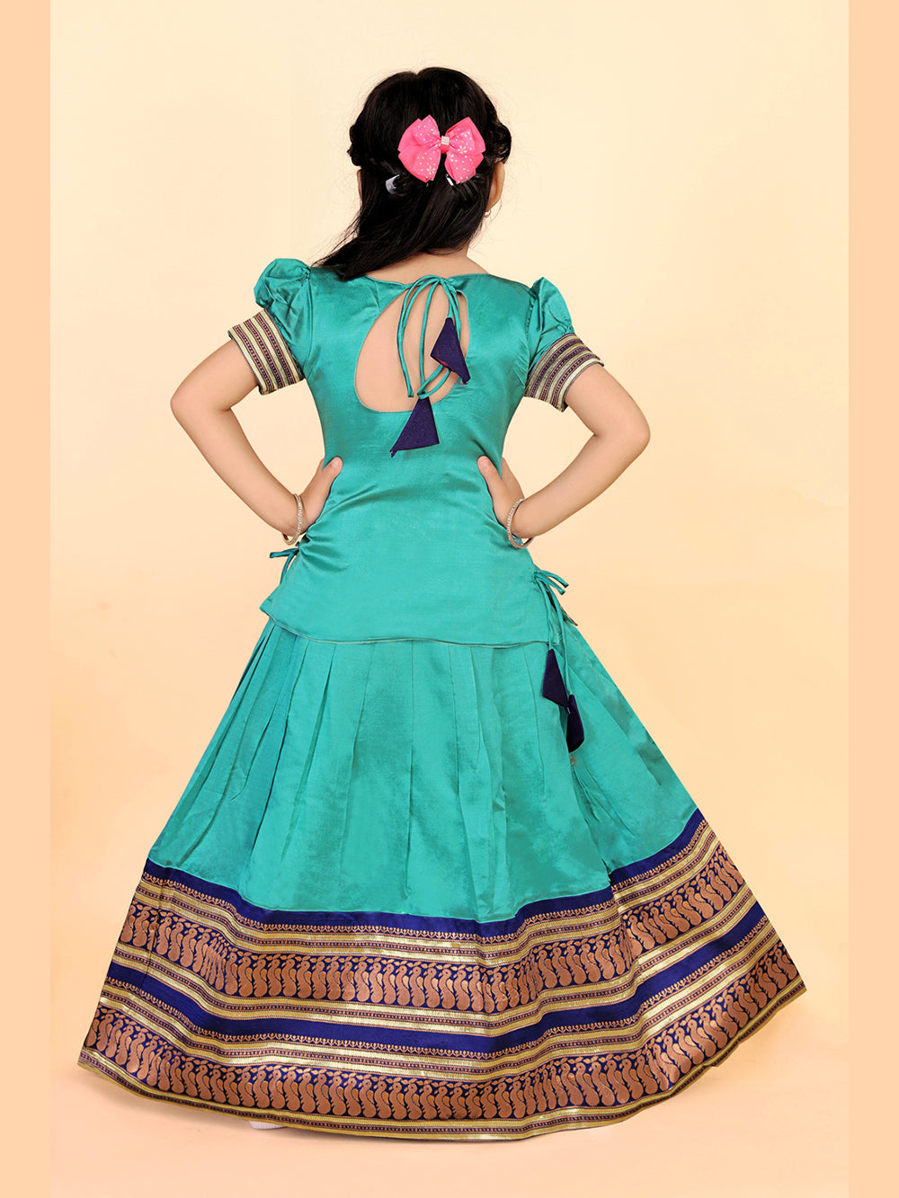 Turquoise traditional outfit with decorative elements on a beige background